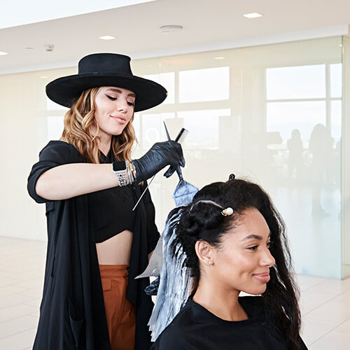 Hairdresser coloring womans hair in salon