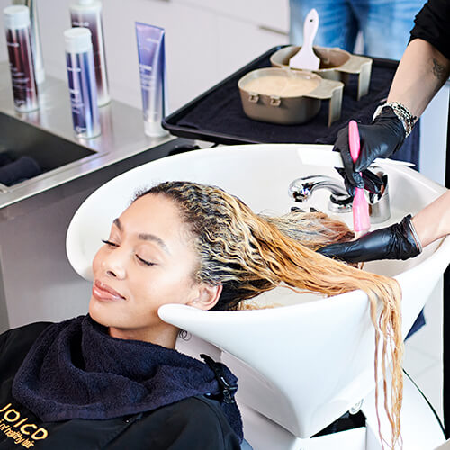 Hairdresser coloring womans hair in salon